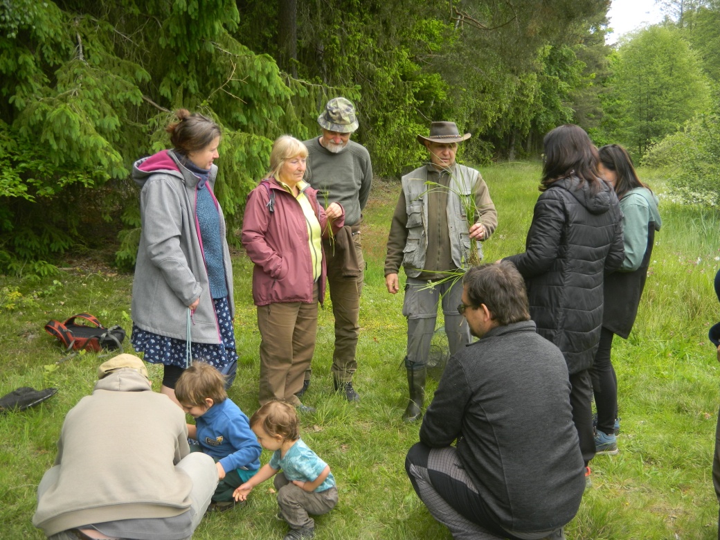 Účastníci vycházky sledují výklad průvodce.