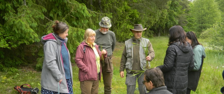 Účastníci vycházky sledují výklad průvodce.